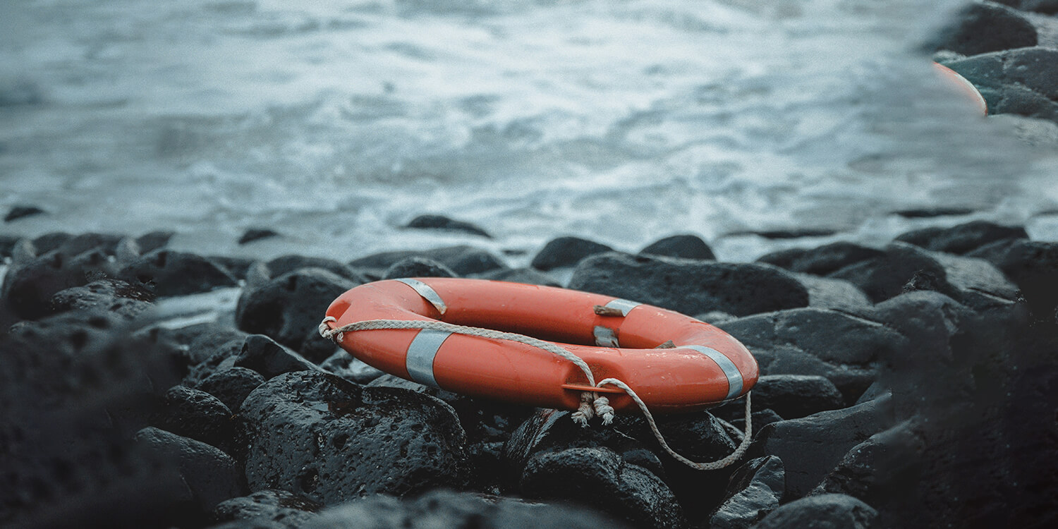 rettungsreifen liegt auf steinen am meer